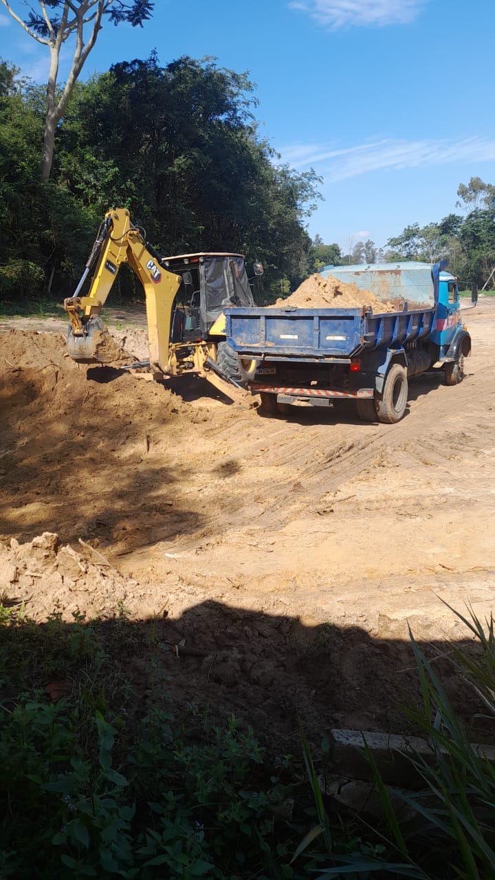 Retroescavadeira e caminhão no local da obra